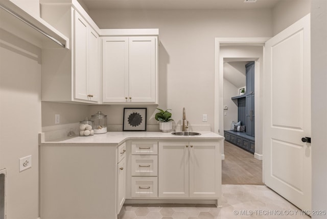 kitchen featuring sink, white cabinetry, and light tile patterned floors