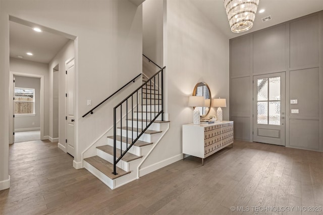 foyer entrance with wood-type flooring and a chandelier