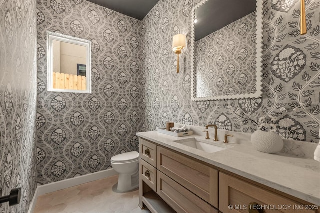 bathroom with toilet, vanity, and tile patterned floors