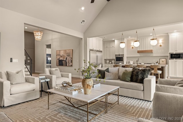 living room featuring sink and high vaulted ceiling