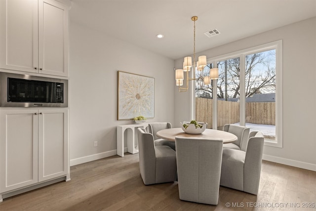 dining area with a notable chandelier and light wood-type flooring