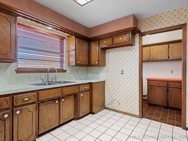 kitchen featuring light tile patterned floors, sink, and a textured ceiling