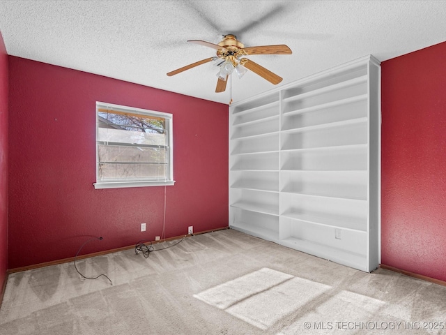 carpeted empty room featuring a textured ceiling and ceiling fan