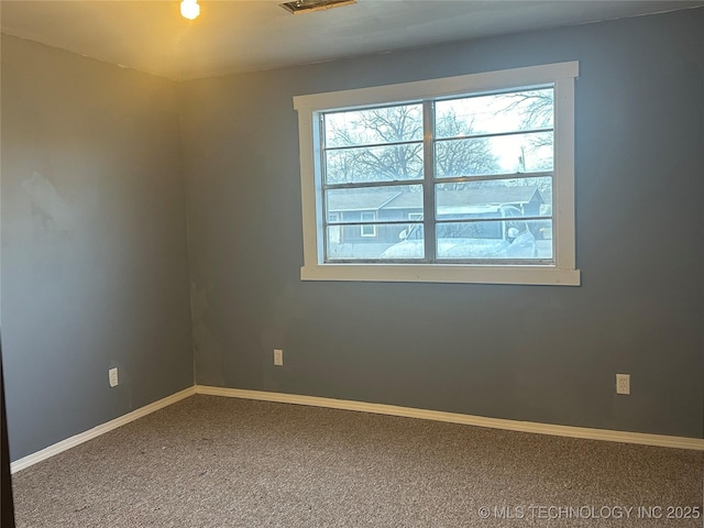 carpeted spare room featuring plenty of natural light