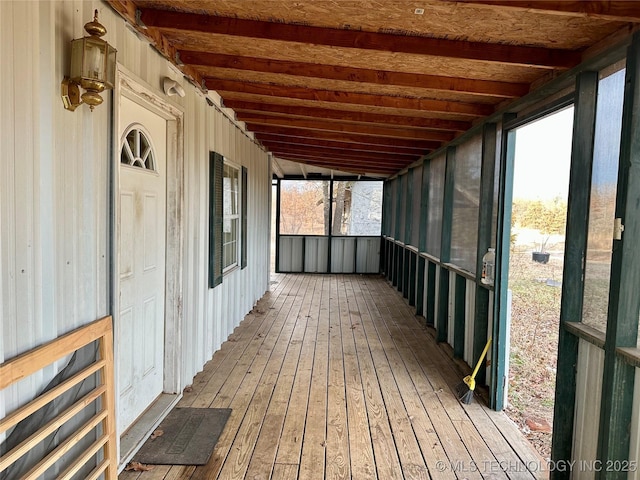 unfurnished sunroom with beam ceiling