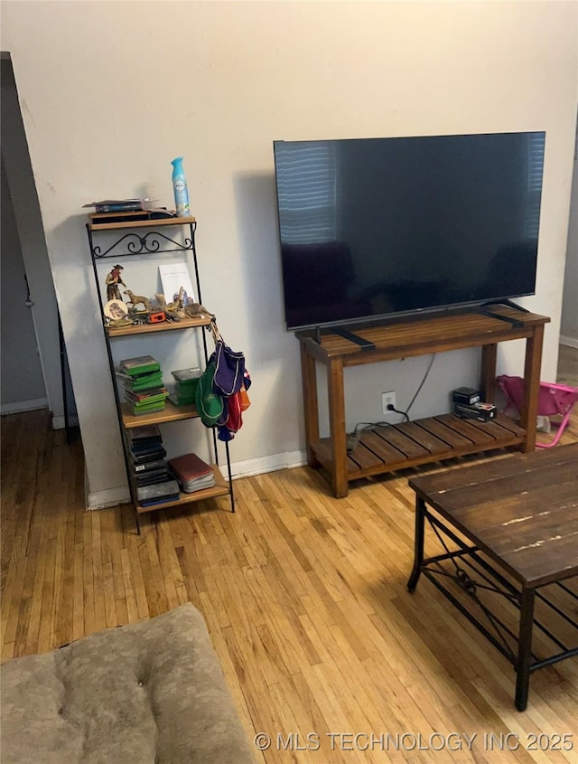 living area featuring baseboards and wood-type flooring