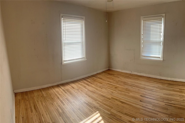 spare room featuring baseboards and hardwood / wood-style flooring