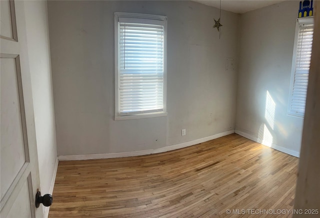 unfurnished room with baseboards and wood finished floors