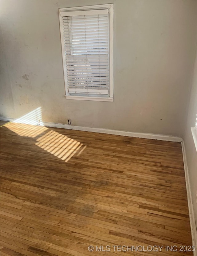 unfurnished room with wood finished floors and baseboards