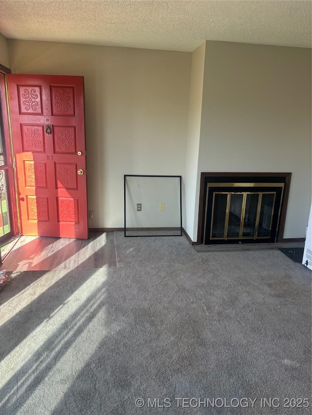 unfurnished living room featuring carpet floors and a textured ceiling