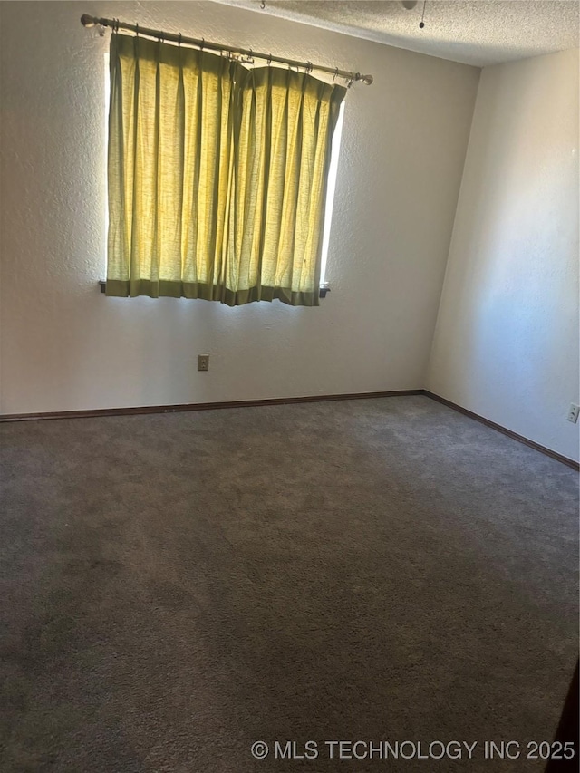 carpeted spare room with a textured ceiling