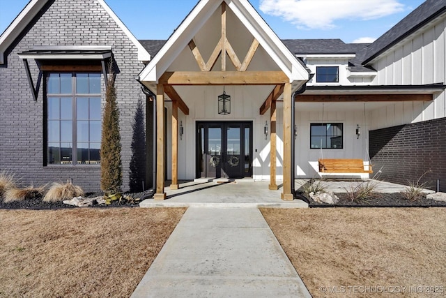 view of exterior entry with covered porch and french doors