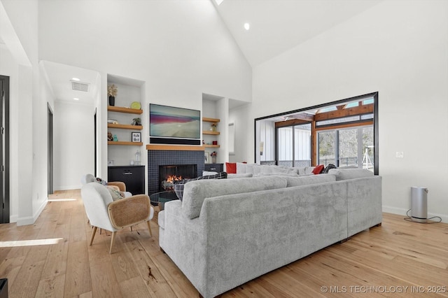 living room with high vaulted ceiling and light wood-type flooring