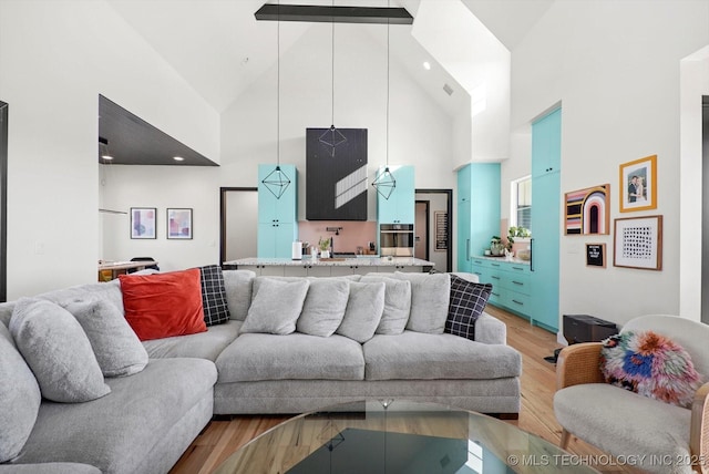 living room with light hardwood / wood-style floors and high vaulted ceiling