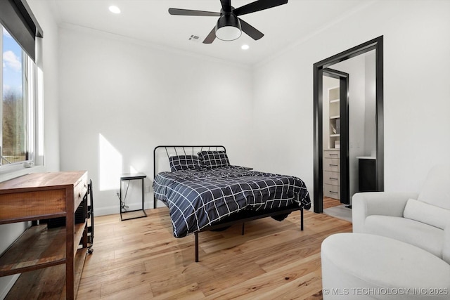 bedroom featuring ceiling fan, crown molding, and light hardwood / wood-style flooring