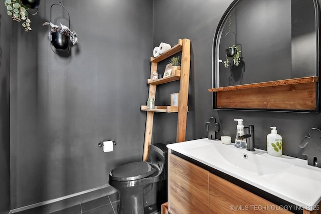 bathroom featuring toilet, tile patterned flooring, and vanity