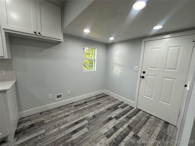 laundry area with dark hardwood / wood-style flooring