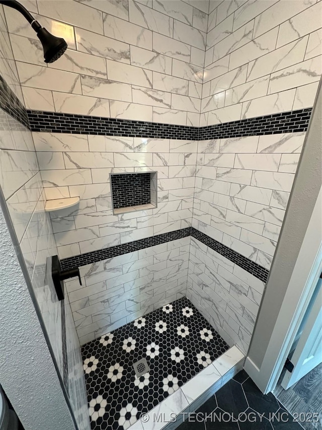 bathroom with tile patterned floors and tiled shower