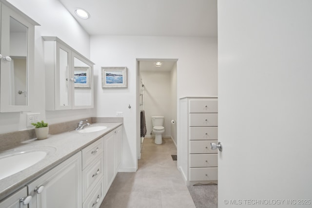 bathroom featuring toilet, vanity, and tile patterned flooring