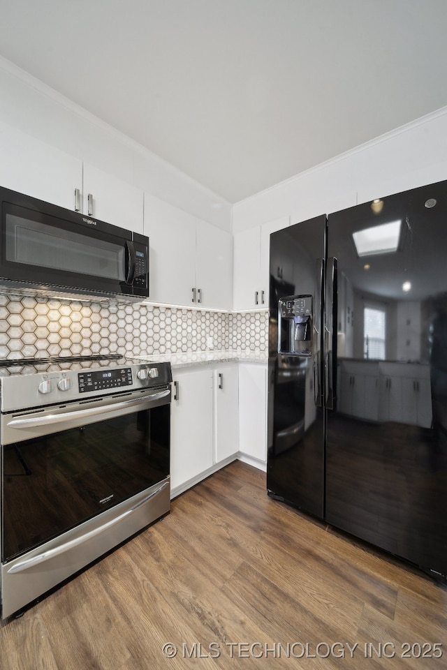 kitchen featuring black appliances, white cabinets, tasteful backsplash, and hardwood / wood-style floors