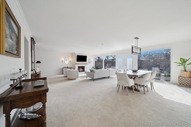 dining room with crown molding, light carpet, and a fireplace