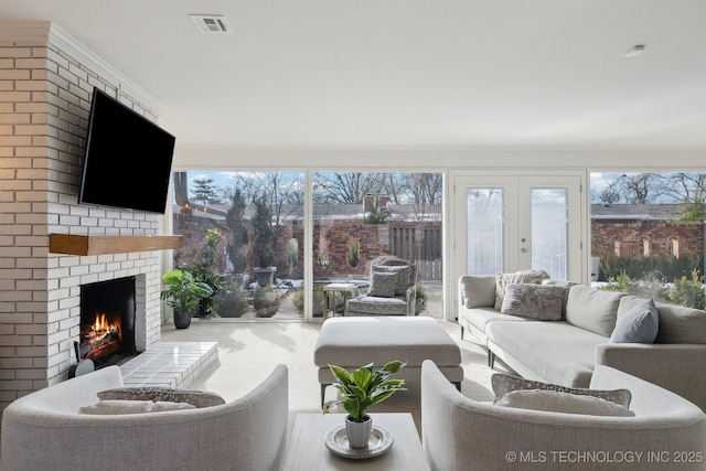 living room featuring french doors, a fireplace, and ornamental molding