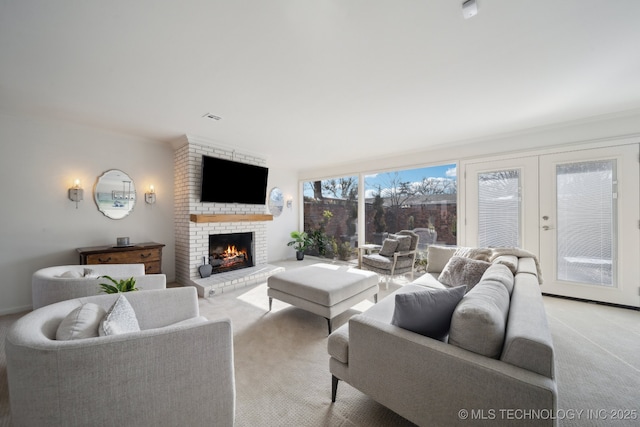 living room featuring a brick fireplace, light colored carpet, and french doors