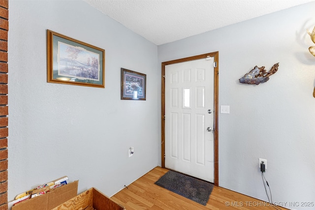 foyer entrance with hardwood / wood-style flooring and a textured ceiling