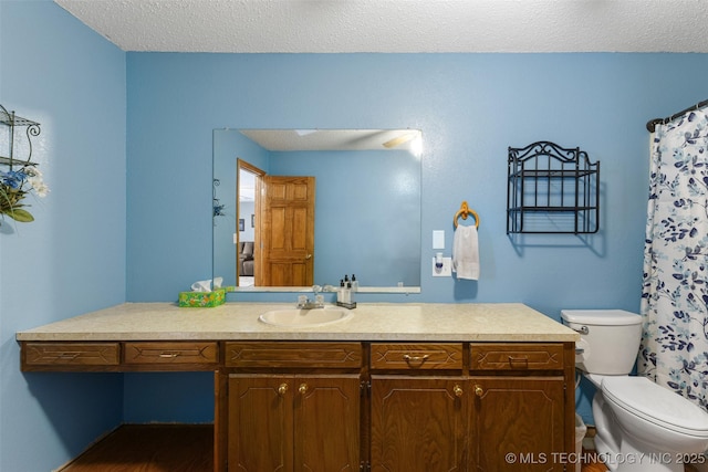 bathroom with vanity, a textured ceiling, and toilet