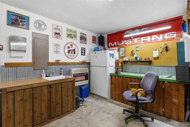 kitchen with white refrigerator, sink, and a textured ceiling