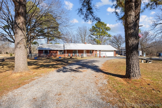 single story home with a garage, a front yard, and covered porch