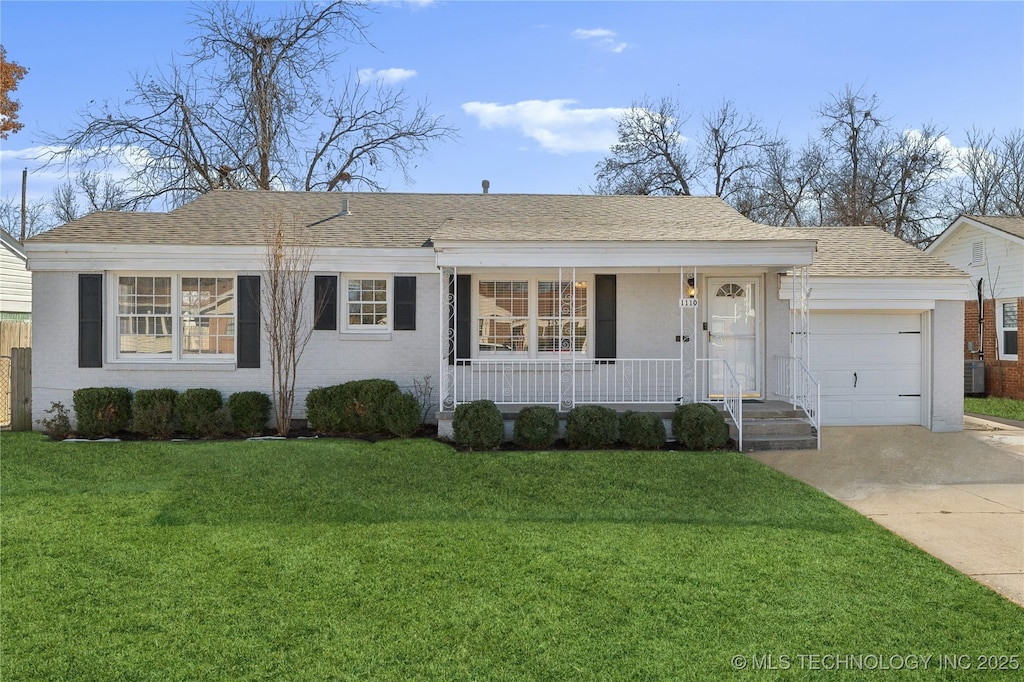 ranch-style house featuring a front yard, covered porch, and a garage