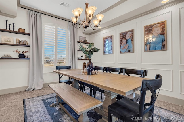 dining room featuring carpet, crown molding, and a notable chandelier