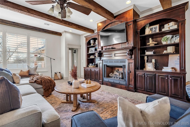 living room featuring ceiling fan, built in features, and beamed ceiling