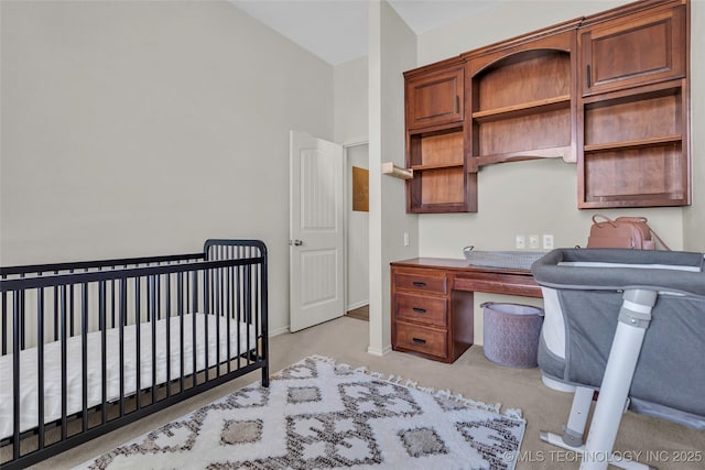 bedroom featuring lofted ceiling and a nursery area