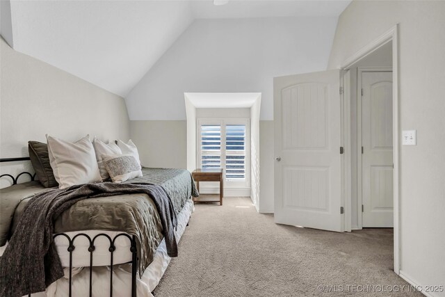 bedroom with light colored carpet and vaulted ceiling