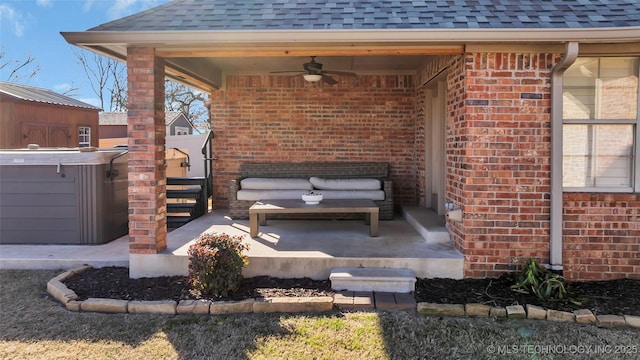 view of patio / terrace featuring ceiling fan, an outdoor living space, and a hot tub