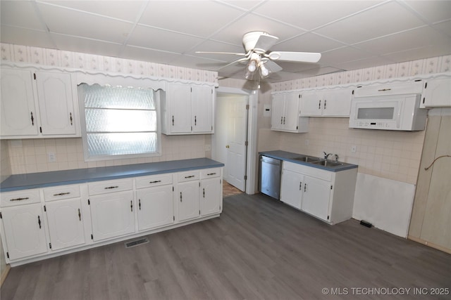 kitchen with dishwasher, dark wood-type flooring, white cabinetry, tasteful backsplash, and a drop ceiling