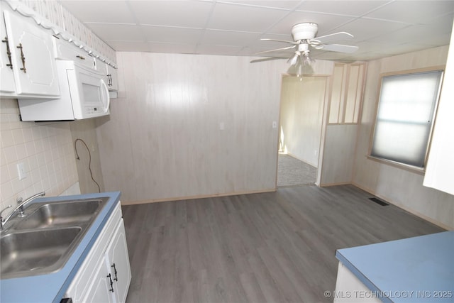 kitchen featuring white cabinets, a drop ceiling, dark hardwood / wood-style flooring, and sink