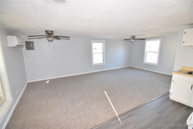 interior space featuring a textured ceiling, ceiling fan, and a wall mounted AC