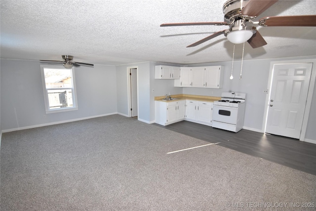 kitchen featuring sink, white cabinetry, white gas range oven, and a textured ceiling