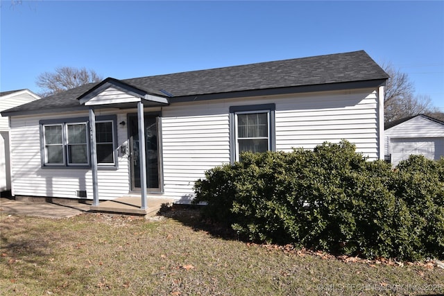 bungalow-style home with a front lawn and a patio