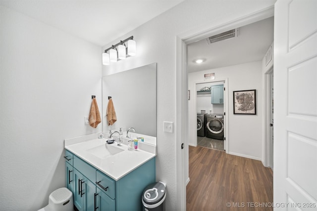 bathroom featuring hardwood / wood-style floors, separate washer and dryer, and vanity