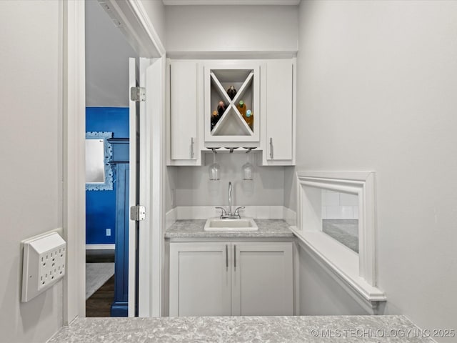 bar featuring white cabinetry and sink