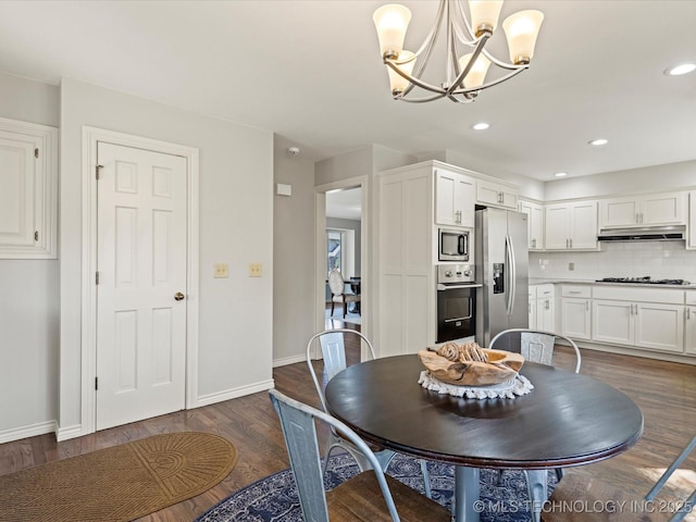 dining space featuring dark wood-type flooring and an inviting chandelier