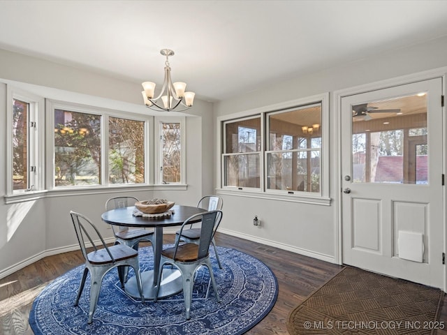 dining room featuring a healthy amount of sunlight, dark hardwood / wood-style floors, and ceiling fan with notable chandelier