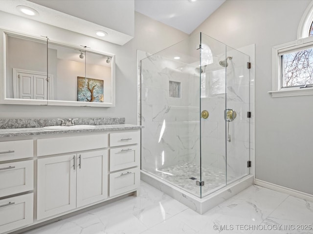 bathroom featuring a shower with door and vanity