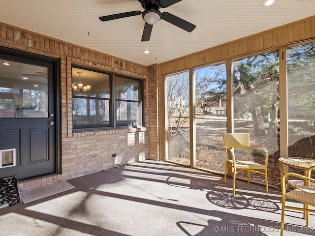 sunroom / solarium featuring ceiling fan with notable chandelier