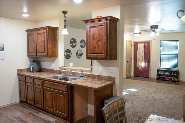 kitchen with ceiling fan, dark hardwood / wood-style floors, hanging light fixtures, and sink