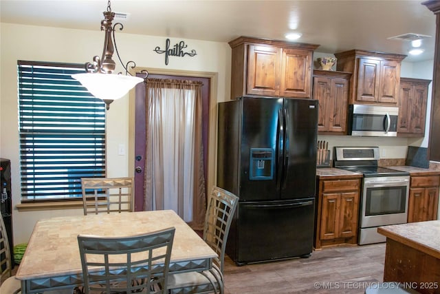 kitchen with appliances with stainless steel finishes and pendant lighting